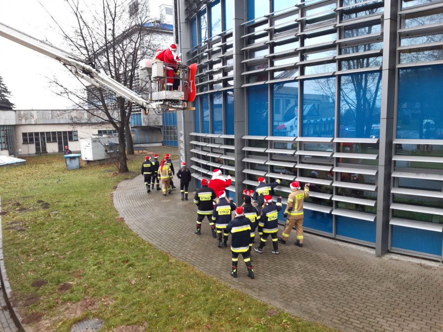 Strażacy ze św. Mikołajem odwiedzili szpital. Z podnośnika machali dzieciom przez okna